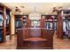 A large walk-in closet with custom shelving, dark wood cabinets and island at 8306 N Merion Way, Paradise Valley, AZ 85253