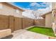 Enclosed backyard with artificial grass, block wall, and patio, offering a low-maintenance outdoor retreat at 8532 E Belleview St, Scottsdale, AZ 85257