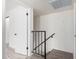 Bright hallway leading to the bedrooms with wood-look flooring and black railing at 8532 E Belleview St, Scottsdale, AZ 85257