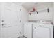 Clean laundry room with a new washer and dryer, shelf, and white door at 8532 E Belleview St, Scottsdale, AZ 85257