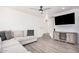 Cozy living room features a comfortable sectional sofa, ceiling fan and large television at 8532 E Belleview St, Scottsdale, AZ 85257
