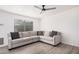 Spacious living room featuring a cozy gray sectional sofa, window, ceiling fan and luxury vinyl plank flooring at 8532 E Belleview St, Scottsdale, AZ 85257