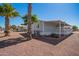 Manufactured home featuring a covered porch, xeriscaping, and mature palm trees at 8823 E Billings St, Mesa, AZ 85207