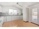 Bright kitchen featuring white cabinetry, mosaic backsplash, modern lighting, and a door to the deck at 8823 E Billings St, Mesa, AZ 85207