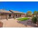 Backyard with covered patio, lounge seating, green grass, desert landscaping, and privacy walls at 9543 E Palomino Pl, Sun Lakes, AZ 85248