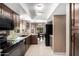 Well-lit kitchen featuring dark cabinetry, an adjacent dining area, and tile flooring at 9543 E Palomino Pl, Sun Lakes, AZ 85248