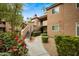 Inviting exterior of a multi-story building with landscaped walkway and mature trees at 10101 N Arabian Trl # 1020, Scottsdale, AZ 85258