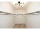 Walk-in closet with carpet floors, modern lighting fixture and metal racks at 1293 E Clifton Ave, Gilbert, AZ 85295