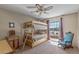 Cozy bedroom featuring a bunk bed, ceiling fan, and a charming accent chair near the window at 13014 W La Terraza Dr, Sun City West, AZ 85375