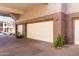Garage under a community overhang with paver driveway, and exterior stone landscape feature at 15221 N Clubgate Dr # 2012, Scottsdale, AZ 85254