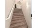 Carpeted staircase with a white handrail and a modern wall sconce at 15221 N Clubgate Dr # 2012, Scottsdale, AZ 85254