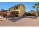 Spacious backyard featuring a covered patio, gravel landscaping, and a colorful outdoor seating area at 15237 N 61St Dr, Glendale, AZ 85306