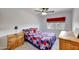 Bright bedroom with a ceiling fan, wooden furnishings, and a red, white, and blue quilt at 15237 N 61St Dr, Glendale, AZ 85306