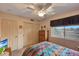 Cozy bedroom with ceiling fan, window with view, carpeted floors, and double door closet at 15237 N 61St Dr, Glendale, AZ 85306