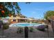 Landscaped backyard oasis with a sparkling pool, mature trees, and a covered hot tub area at 15237 N 61St Dr, Glendale, AZ 85306