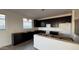 Bright kitchen with black cabinetry, an island, modern recessed lighting, and tile flooring at 15764 W Beryl Ave, Waddell, AZ 85355