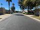 A quiet neighborhood street featuring well-maintained homes with desert landscaping and mature shade trees at 19224 N 93Rd Ave, Peoria, AZ 85382