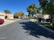 Quiet neighborhood street featuring well-maintained homes, green lawns and mature shade trees on a bright, sunny day at 19224 N 93Rd Ave, Peoria, AZ 85382