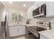 Modern kitchen with stainless steel appliances, white cabinets, tile backsplash, and a bright window at 19400 N Westbrook Pkwy # 241, Peoria, AZ 85382