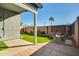 Inviting backyard featuring artificial grass, mature landscaping, and a charming outdoor fire pit at 2145 E Danbury Rd, Phoenix, AZ 85022