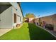 Backyard with artificial turf, mature plants, storage shed, and walkway around the perimeter at 2145 E Danbury Rd, Phoenix, AZ 85022