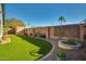 Lush backyard with artificial turf, privacy wall, mature plants, and outdoor storage shed at 2145 E Danbury Rd, Phoenix, AZ 85022