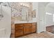 Well-lit bathroom featuring a neutral patterned accent wall, wood vanity, and shower with a built-in seat at 2145 E Danbury Rd, Phoenix, AZ 85022