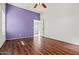This bedroom features wood floors, white trim, windows, and purple accent wall at 2145 E Danbury Rd, Phoenix, AZ 85022