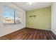 Bedroom with hardwood floor, ceiling fan, window view, and wall-mounted shelving at 2145 E Danbury Rd, Phoenix, AZ 85022