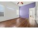 The bedroom features wood floors, white trim, windows, and purple accent wall at 2145 E Danbury Rd, Phoenix, AZ 85022
