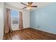 Bright bedroom features a ceiling fan, wood floors, and light blue accent wall at 2145 E Danbury Rd, Phoenix, AZ 85022