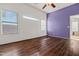 This bedroom features wood floors, white trim, windows, and purple accent wall at 2145 E Danbury Rd, Phoenix, AZ 85022