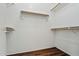 Walk-in closet with wood-look floors and multiple shelves for optimal storage and organization at 2145 E Danbury Rd, Phoenix, AZ 85022