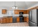 Well-equipped kitchen with black appliances, wood cabinets, tile floors, and modern lighting at 2145 E Danbury Rd, Phoenix, AZ 85022
