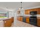 Open kitchen area featuring wood cabinets, tile floors, breakfast bar, and backyard views at 2145 E Danbury Rd, Phoenix, AZ 85022