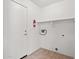 Clean laundry room with storage shelf, tile floor, and utility hookups for a modern appliance set at 2145 E Danbury Rd, Phoenix, AZ 85022