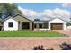 Inviting single-story home with manicured lawn, brick driveway, and a modern two-car garage at 220 E Georgia Ave, Phoenix, AZ 85012