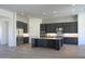 Modern kitchen with a large center island, dark cabinetry, and stainless steel appliances at 23964 N 128Th Pl, Scottsdale, AZ 85255