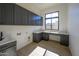 Functional laundry room with custom cabinetry, sink, and countertop space, perfect for organization at 23964 N 128Th Pl, Scottsdale, AZ 85255