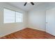 Bright bedroom with ceiling fan and window with blinds, wood-look flooring at 2444 S Terrell --, Mesa, AZ 85209