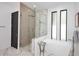 Spa-like bathroom with a sleek standalone tub and frameless shower, offering a serene retreat at 3106 N Valencia Ln, Phoenix, AZ 85018