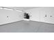 Clean garage featuring a speckled gray epoxy floor, utility connections and a bright white door at 3106 N Valencia Ln, Phoenix, AZ 85018