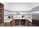 A well-organized butler's pantry with open shelving, marble countertops, and stainless steel wine coolers at 3106 N Valencia Ln, Phoenix, AZ 85018