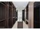 Spacious walk-in closet with custom shelving, dark wood cabinetry, and natural light from a window at 3106 N Valencia Ln, Phoenix, AZ 85018