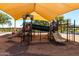 Modern playground covered by a sunshade offering a safe and fun environment for children to play at 36579 W Barcelona Ln, Maricopa, AZ 85138
