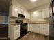 Efficient kitchen featuring white cabinets, black appliances, and a window view at 3810 W Belmont Ave, Phoenix, AZ 85051