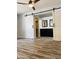 Bedroom features wood-look floors, ceiling fan, and sliding barn door to bathroom at 4007 W Rue De Lamour Ave, Phoenix, AZ 85029