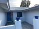 Inviting entryway featuring a stylish blue door and decorative planters atop white pillars at 4007 W Rue De Lamour Ave, Phoenix, AZ 85029