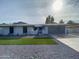 Attractive single-story home with manicured lawn and updated gray exterior paint and garage door at 4007 W Rue De Lamour Ave, Phoenix, AZ 85029