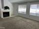 A well lit living room featuring plush carpet, a fireplace, and two large windows at 4335 E Monte Way, Phoenix, AZ 85044